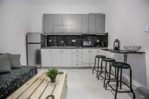 cocina con sofá, mesa y taburetes en Terra di Meteora Suites #3, en Kalambaka
