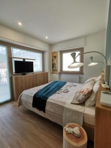 a bedroom with a large bed and a television at L'Atelier du Temps - Elvimo Apartment in Aosta