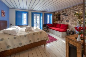 a bedroom with a bed and a red couch at Archontiko Dilofo in Dilofo