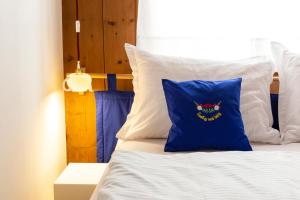 Bett mit blauem Kissen darüber in der Unterkunft Historic Homes Zafig in Latsch