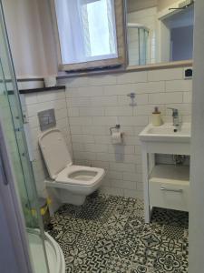 a bathroom with a toilet and a sink at Willa Aura Mare in Dziwnów +71 photos