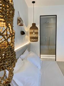 una camera con letto e lampadario a braccio di Andros Utopia a Mpatsi (Batsi)