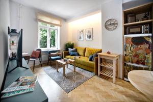 ワルシャワにあるOCHOTA P&O Serviced Apartmentsのリビングルーム(黄色のソファ、テーブル付)