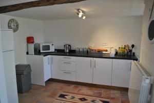 a kitchen with white cabinets and a black counter top at Maison Belle Vue in Cherval