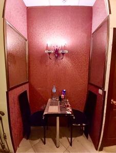 ドニプロにあるPortal Мини Отельの赤い壁の前にテーブルと椅子2脚