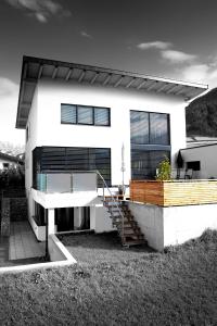 uma casa branca com uma escada em frente em Lux Alpinae em Nauders