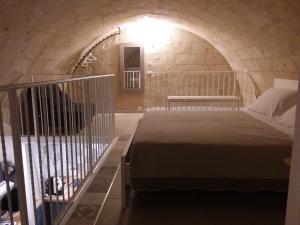 een slaapkamer met een bed in een stenen kamer bij POZZO FIORITO in Matera