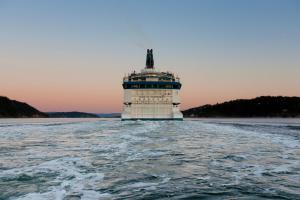 a cruise ship in the water with a lighthouse at DFDS Ferry - Oslo to Frederikshavn in Oslo