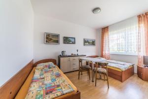 a bedroom with two beds and a table at Pokoje gościnne Neptun in Ostrowo