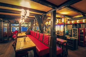 un restaurante con mesas y cabinas rojas en una habitación en Zur alten Krone en Hattingen