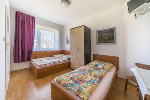 a bedroom with two beds and a window at Pokoje gościnne Neptun in Ostrowo