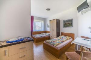 a room with two beds and a sink in it at Pokoje gościnne Neptun in Ostrowo