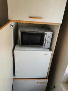 a microwave sitting on top of a refrigerator at Ferienwohnung Solebad in Gmünd +10 photos