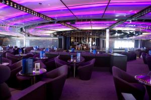 a room with purple lighting and tables and chairs at DFDS Ferry - Oslo to Frederikshavn in Oslo