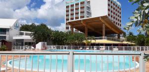 una piscina en un complejo con un gran edificio en Studio entre ciel et mer sans coupure d'eau, en Le Gosier