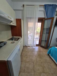 uma cozinha com um lavatório e uma porta para um pátio em Gallery em Ammouliani