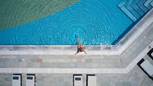 a person standing in front of a swimming pool at Elysia Park in Paphos