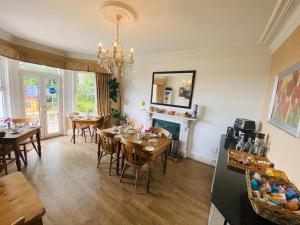 a dining room with tables and chairs and a fireplace at NORTHRISE RETREAT in Hastings