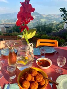 uma mesa com um prato de comida e um vaso de flores em Il Monte Farmhouse em Torricella Peligna