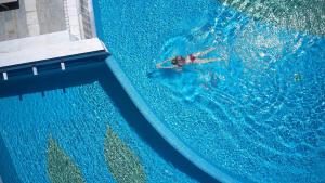 a person swimming in a swimming pool at Elysia Park in Paphos