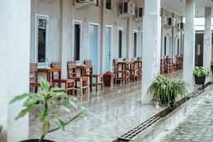 a corridor of a building with tables and chairs at Pondok Kelapa Homestay near Unila Lampung RedPartner in Bandar Lampung