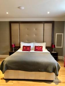 a bedroom with a large bed with two red pillows at Lensfield Hotel in Cambridge