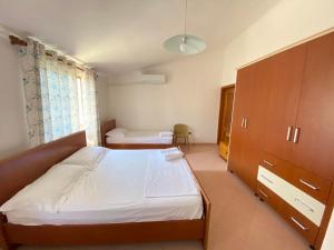 a bedroom with a bed and a dresser at Guest House Lionel in Durrës
