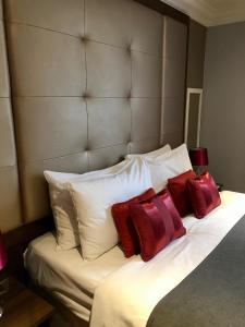 een bed met rode en witte kussens erop bij Lensfield Hotel in Cambridge