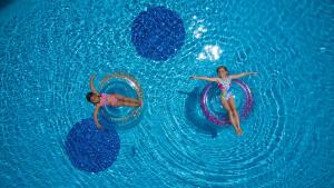 two girls are playing in a swimming pool at Elysia Park in Paphos