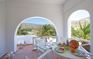 a dining room with a table and chairs and two windows at Villa Katapoliani No.3 in Katapola