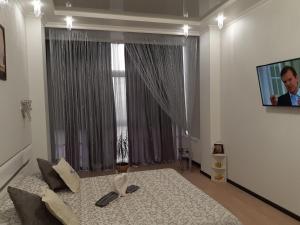 a bedroom with a large window with a man on a tv at Маршала Малиновського 18 б 12 Жемчужина квартира in Odesa