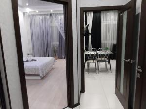 a bedroom with a bed and a dining room with a table at Маршала Малиновського 18 б 12 Жемчужина квартира in Odesa