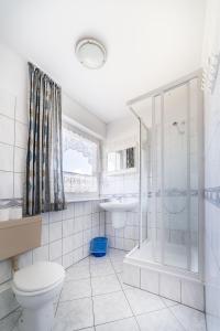 a bathroom with a toilet and a shower and a sink at Pokoje gościnne Neptun in Ostrowo