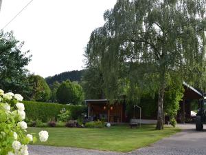 een huis met een boom ervoor bij Ferienwohnung Veischedetal im Sauerland in Lennestadt