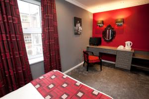 a room with a bed, table and a window at St James Hotel; BW Premier Collection in Nottingham