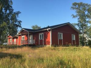 a red house in a field of tall grass at Hotell Gullvivan in Brändö