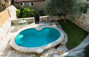 a swimming pool in a yard with a stone wall at Villa Maslina in Cavtat