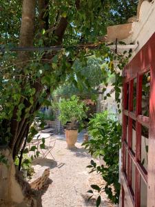 an arched walkway next to a building with trees at liste rouge in Nîmes