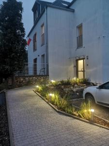 samochód zaparkowany przed budynkiem z oświetleniem w obiekcie Apartamenty Lawendowy Zakątek 2 w mieście Opole