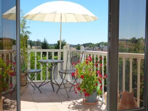 a balcony with a table and an umbrella at Maison Pierre D'Or in Sarlat-la-Canéda