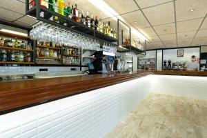 un bar con bancone in legno e alcune bottiglie di Ciudad De Vacaciones Cala Montjoi a Roses