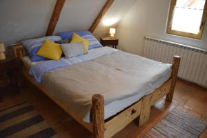 a bedroom with a bed with blue and yellow pillows at Kuća za odmor Mećava in Mrkopalj