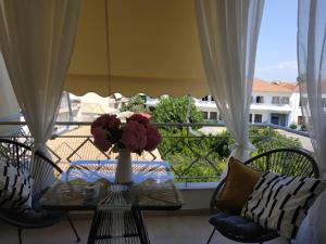 a table with a vase of flowers on a balcony at Cozy and Style in Preveza