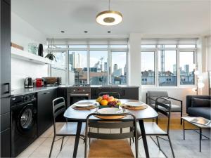 a kitchen and dining room with a table with fruit on it at D8 - Hoxton Square Penthouse in London