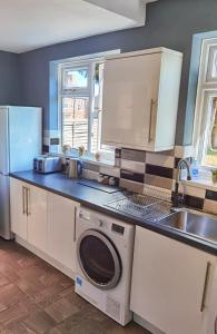 a kitchen with a washing machine and a sink at Perry Road, beautiful large house available for Guests and Contractors Parking wifi in Nottingham