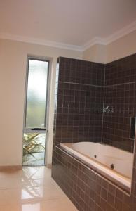 a bathroom with a tub and a window at Harbour Lookout in Strahan