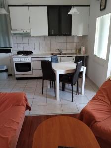 - une cuisine avec une table et des chaises blanches dans la chambre dans l'établissement Apartment Šibenik Mandalina, à Šibenik