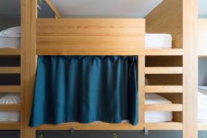 a bunk bed with a blue curtain in a room at Yeah Barcelona Hostel in Barcelona