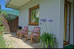 a patio with two chairs and a table and a plant at Traar Walter und Edeltraut in Scherzboden