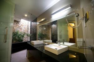 un bagno con due lavandini e un grande specchio di Miridiya Lake Resort a Anuradhapura